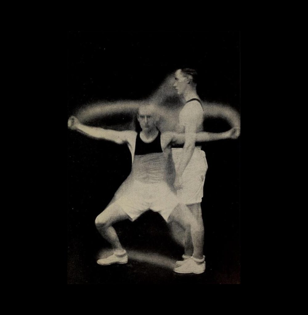 An image of a man dressed in exercise gear performing two different poses that demonstrate an exercise. In one pose, the man is standing straight, facing to the left. In the other pose, he is standing facing the camera with arms and legs outspread. The images are overlayed on top of each other, creating the effect of motion between the two poses.
